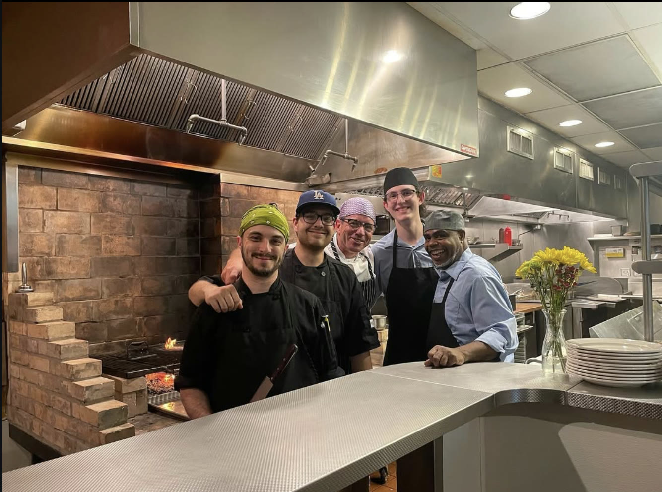 The Steer kitchen crew smiling together by the wood-fired grill